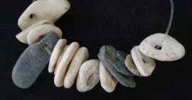 Cuentas de piedra que componían un collar hallado en la tumba 22 del Cerro de la Encina (Museo Arqueológico y Etnológico de Granada)